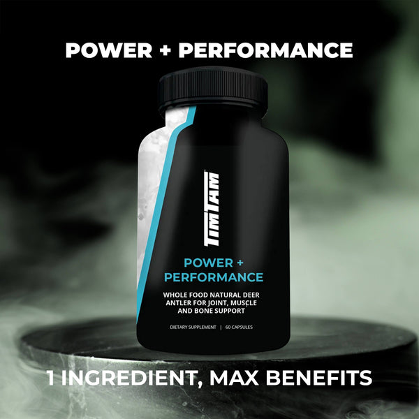 Black supplement bottle labeled 'Power + Performance' on a dark background